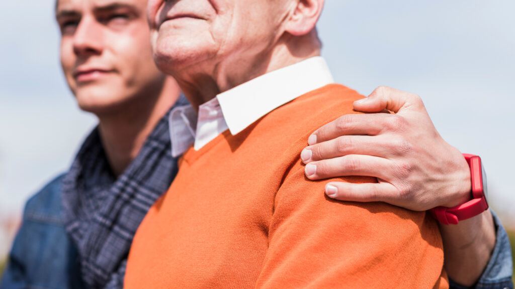 son embraces his father as they contemplate the landscape