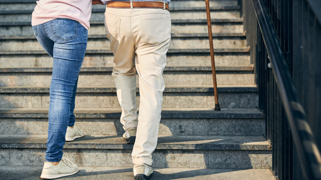 an older person being helped up the stairs