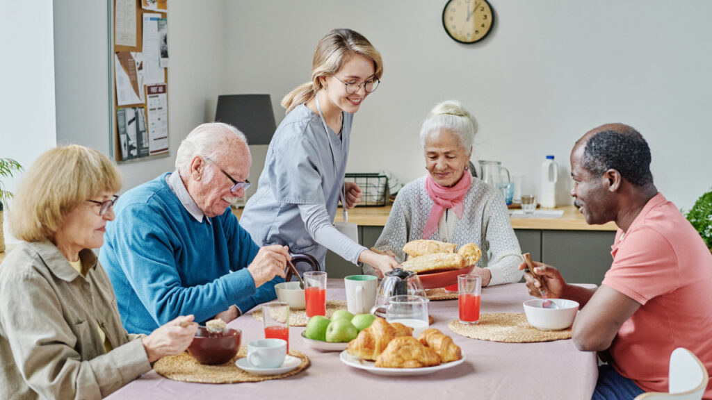 Older people sitting at the table eating