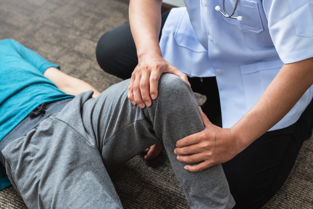 A physiotherapist assessing their patient's knee